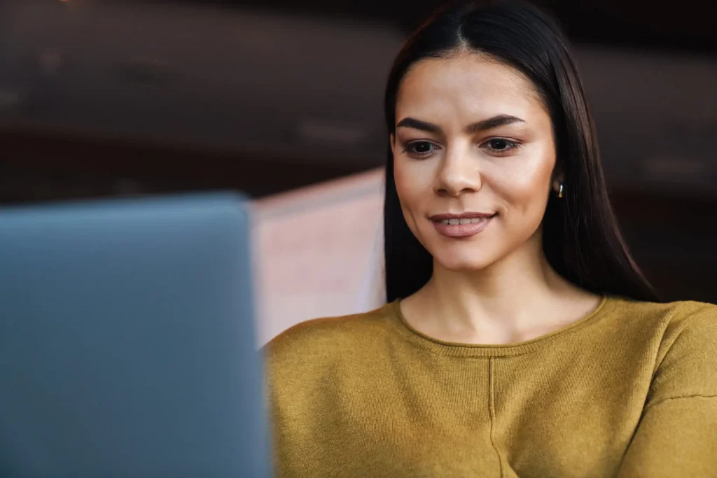Image of young caucasian businesswoman working on laptop in offi