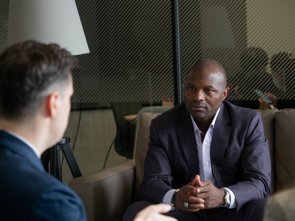 two men sitting talking in business suits