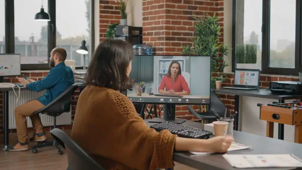 Entrepreneur talking to manager on video call about business