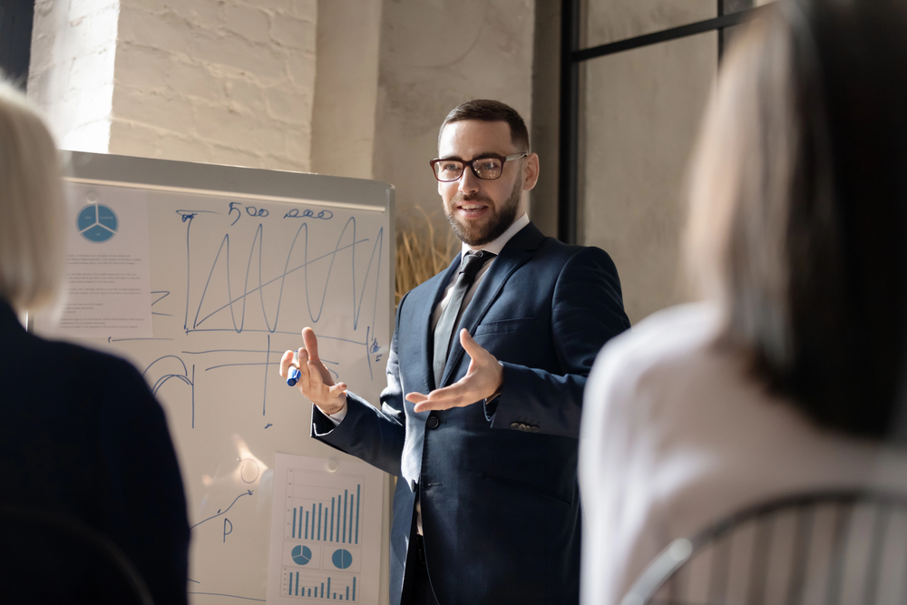 man coaching at whiteboard