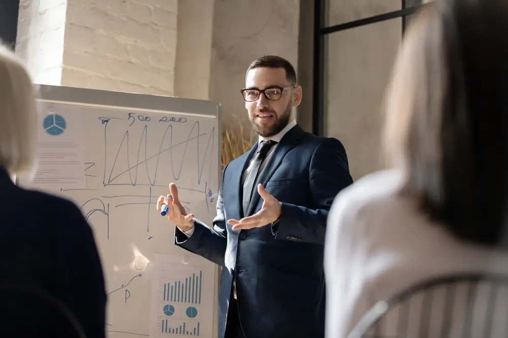 man coaching at whiteboard