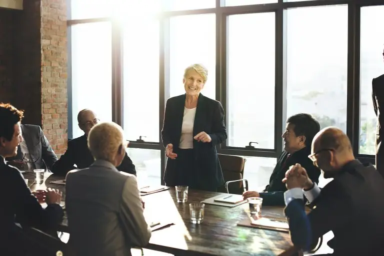 Business woman standing up at a corporate meeting