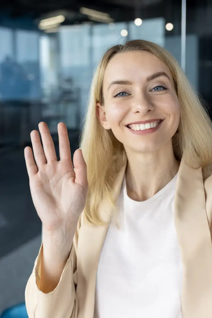 smiling woman waving hello