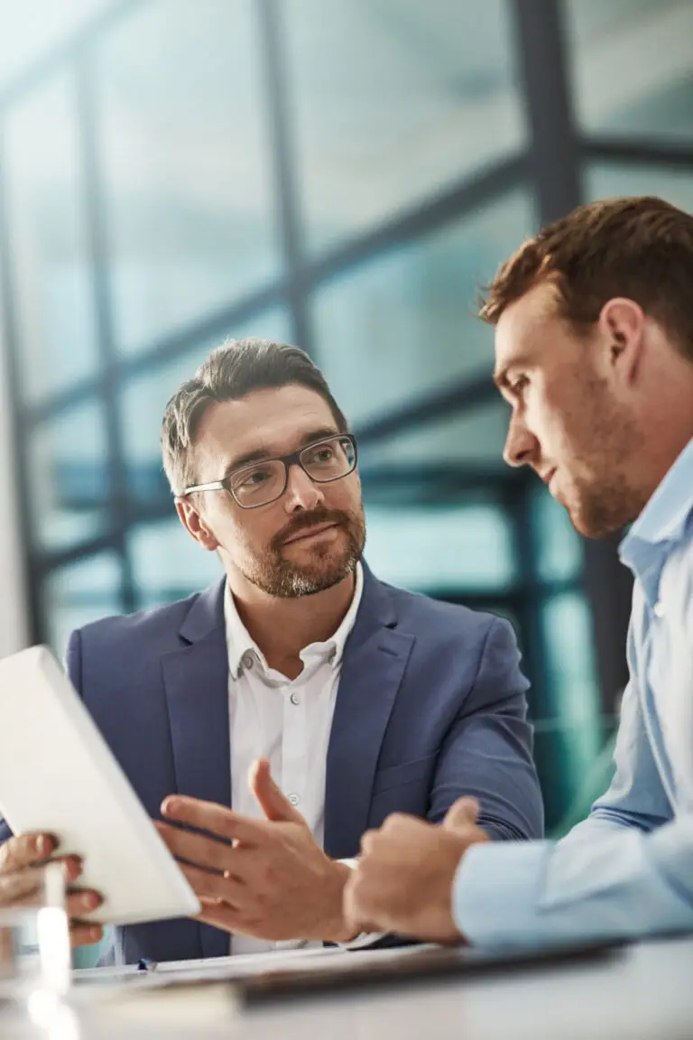 Coaching, training and business people with tablet in office workplace. Collaboration, mentor and men or employees with technology planning sales, marketing or advertising strategy in company meeting.