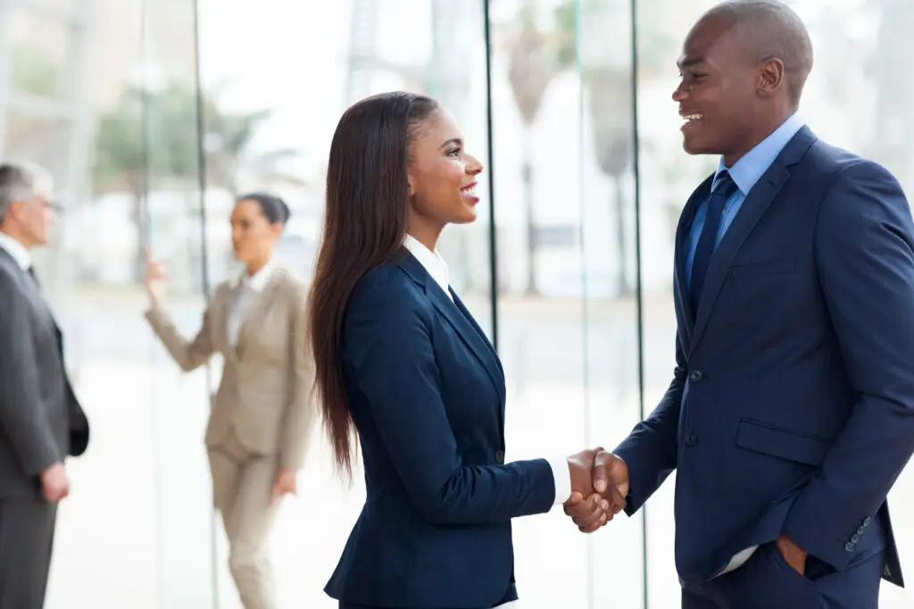 two people shaking hands in corporate lobby coaching