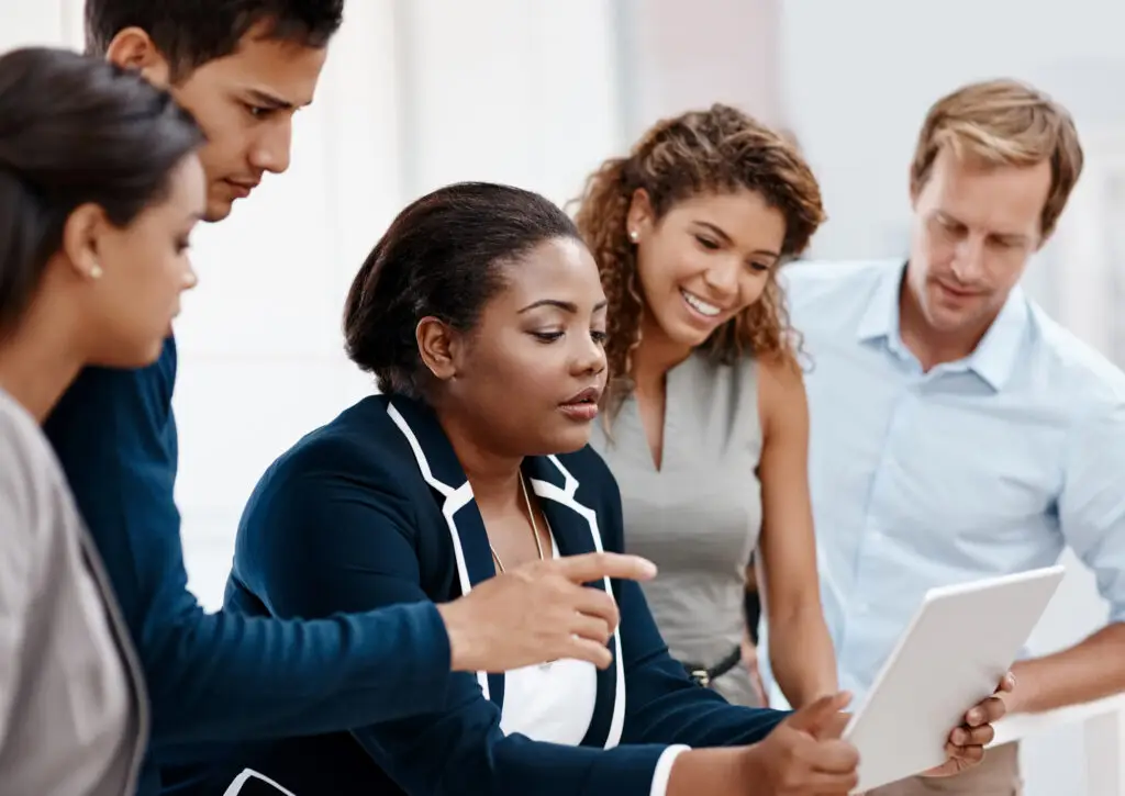 business people sitting and standing looking at tablet for coaching