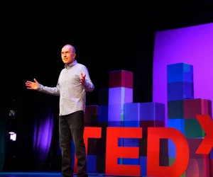 man speaking at ted talk
