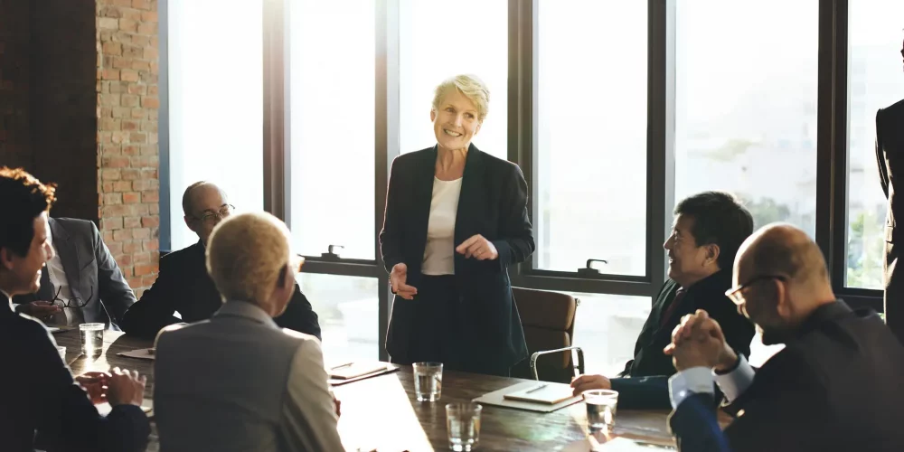Business woman standing up at a corporate meeting